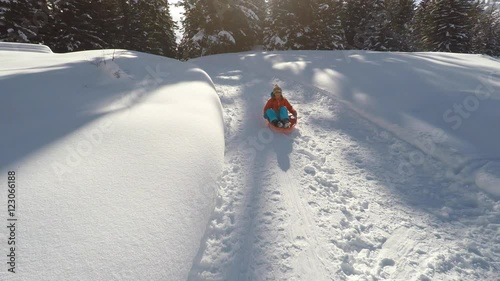 Girl enjoying sleigh ride. Sledding aerial shot.