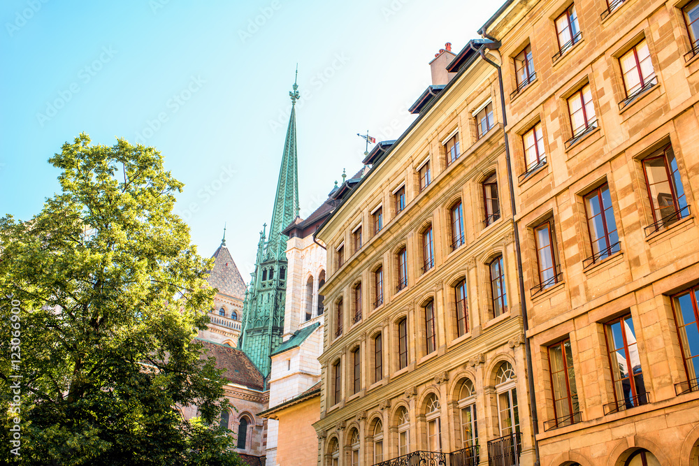 Obraz premium Street view with old buildings and Saint Pierre church's spire in the old town of Geneva city in Switzerland