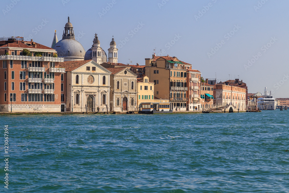 Facades of houses and the bridge, the view from the water in the channel of Giudecca in the Italian city of Venice