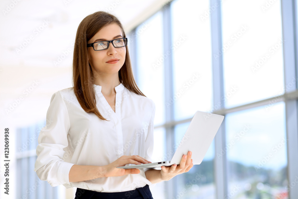 Portrait of modern business woman working with laptop computer in the office, copy space area Portrait of modern business woman working with laptop computer in the office, copy space area