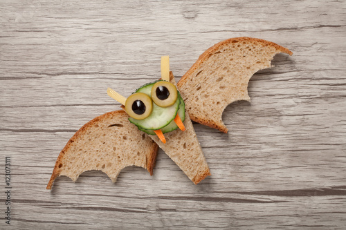 Halloween bat made of bread on wooden background