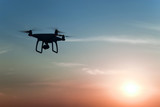 Quadrocopters silhouette against the background of the sunrise