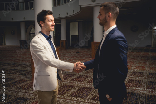 Young Muslim men handshaking in a mosque. photo