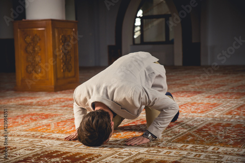 Young Muslim praying in a mosque.