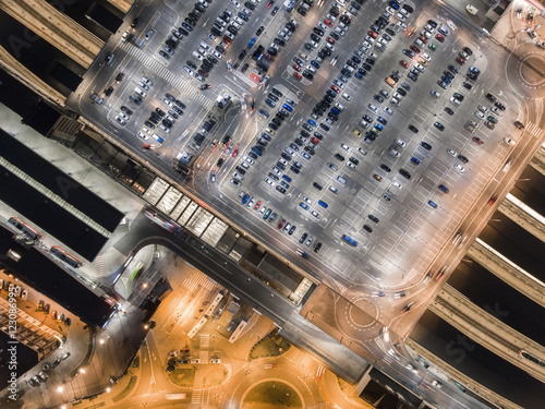 Transportation, cars on big parking at night. Aerial view in Krakow, Poland. Railway station and autobus station