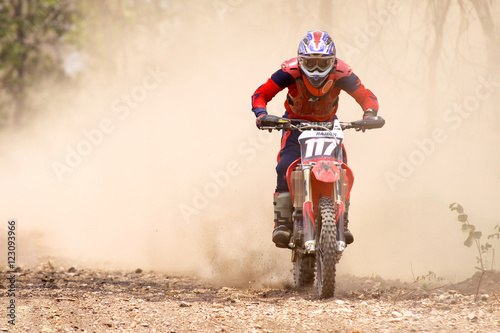 Fototapeta Naklejka Na Ścianę i Meble -  Motocross rider accelerating in dust track