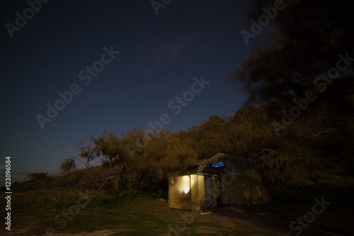 lluminated tent on a starry night, Fraser Island, Australia