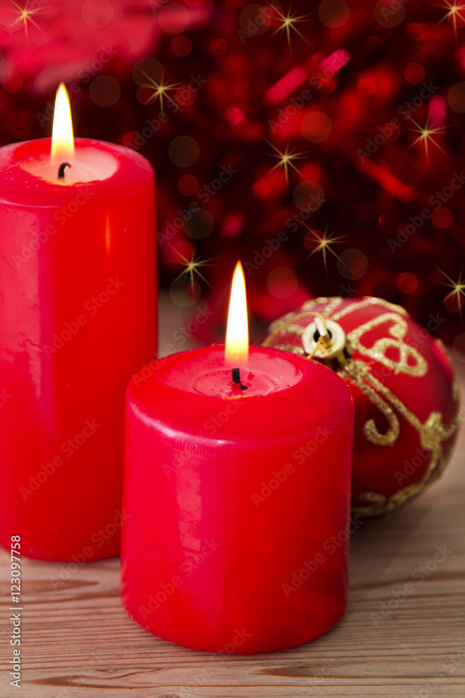lit candles and Christmas balls on red background lit candles and Christmas balls on red background