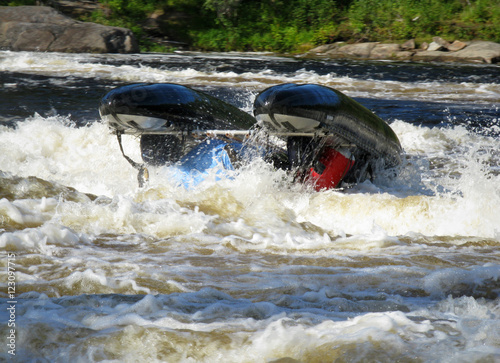 The catamaran is turning over in the rapid river photo