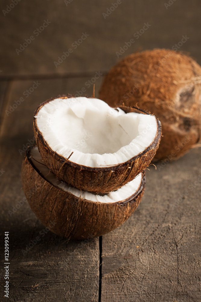 Ripe half cut coconut on a wooden background. Ripe half cut coconut on a wooden background.