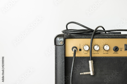 Black guitar amplifier with jack cable on white background photo