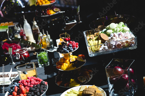 A look from above on a black buffet full of delicious fruits and © nastasenko