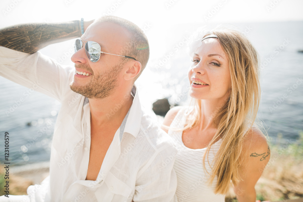 Fashion model couple with tattoo posing outside nea sea