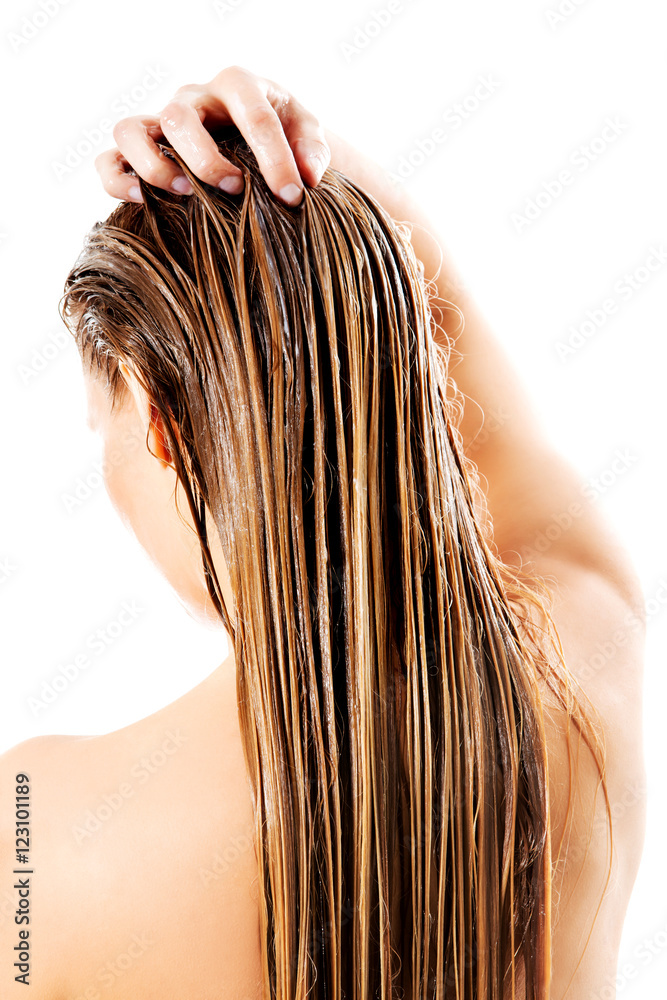 Naklejka premium Woman applying hair conditioner. Isolated on white.
