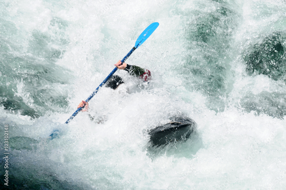 Obraz premium Active kayaker rolling and surfing in rough water 