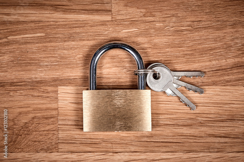 Padlock and keys on a brown wooden table