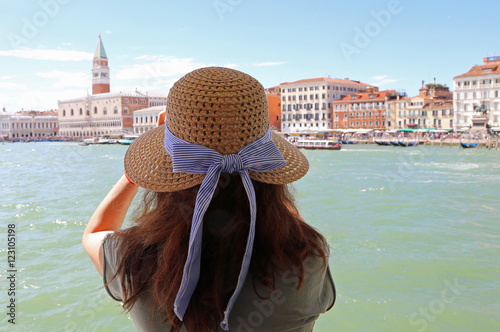 woman with long brown hair and a straw hat and the great bell to photo