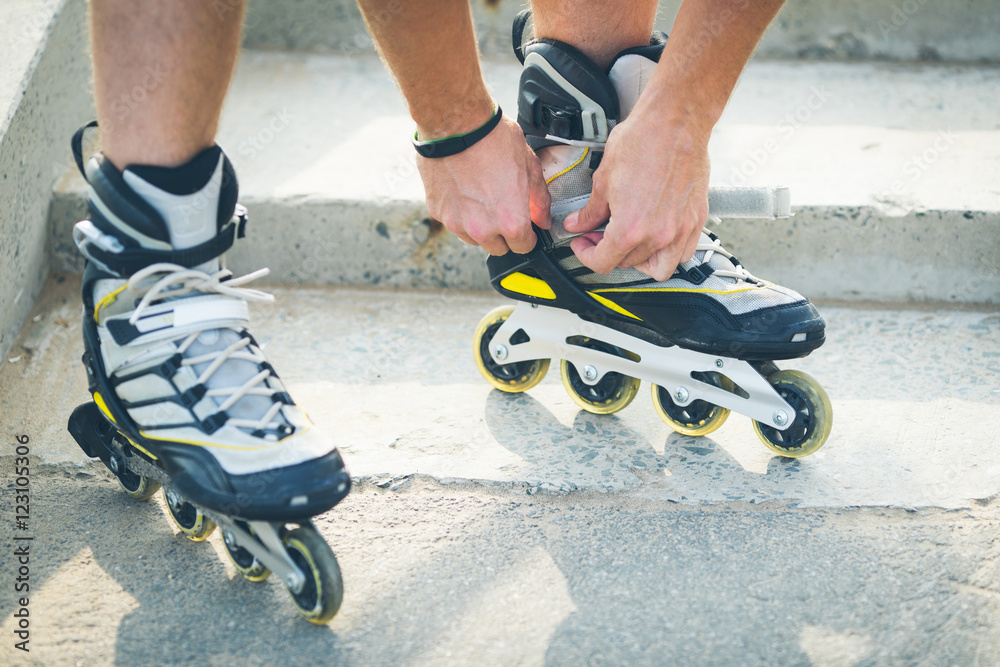 Obraz premium Man preparing for roller skating, putting on rollerskates