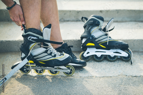 Foto Man preparing for roller skating, putting on rollerskates
