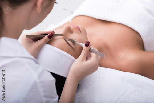 Bild auf Leinwand Professional beautician undergoing eyelash extension procedure