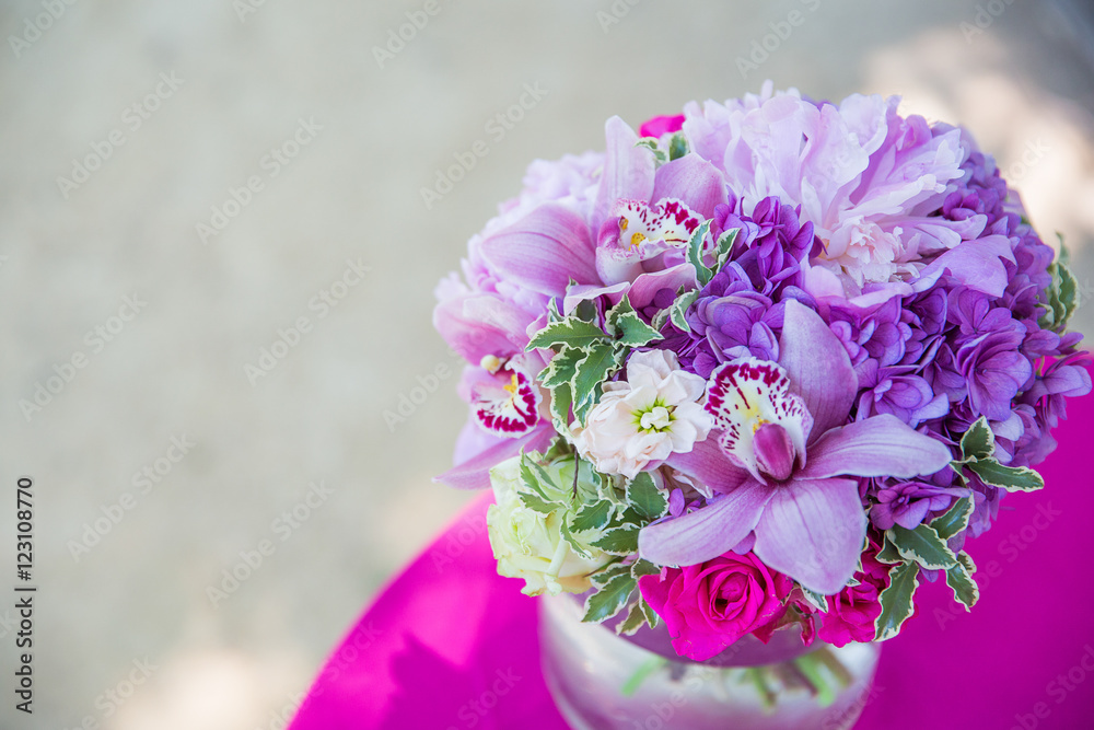 A bouquet made of violet flowers stands on the pink tablecloth A bouquet made of violet flowers stands on the pink tablecloth