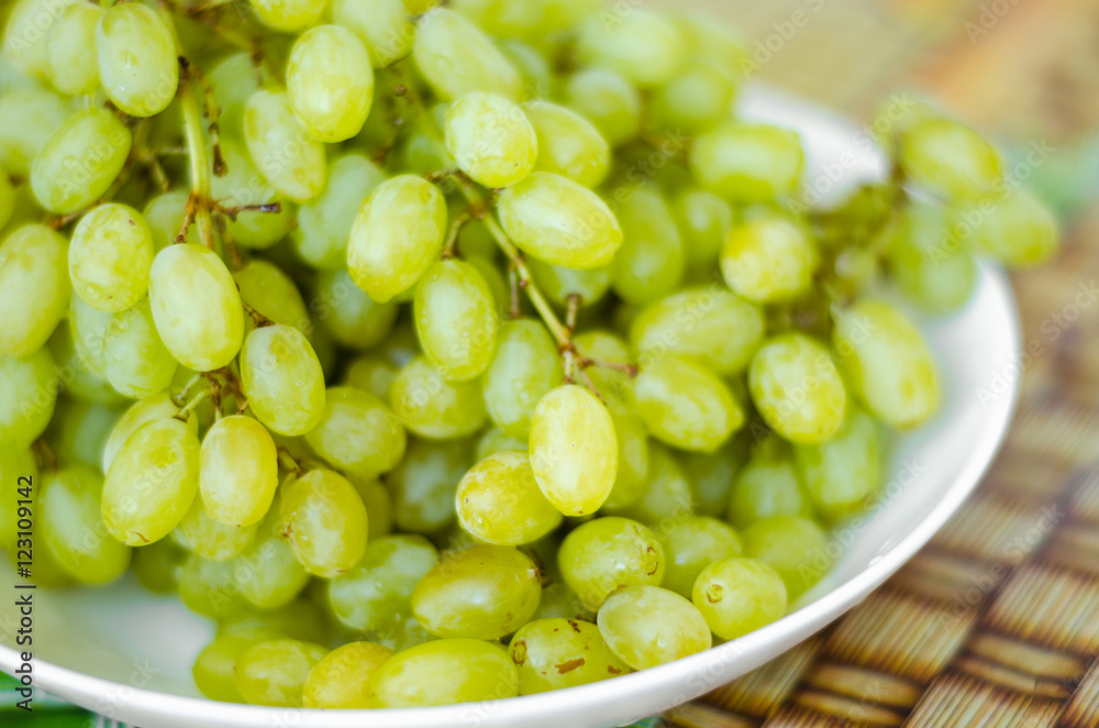 Color photo of green grapes called a white plate. Color photo of green grapes called a white plate.