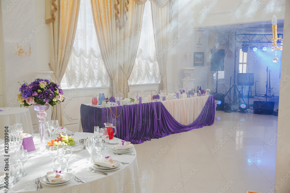 Sunshine illuminates a restaurant hall decorated in violet tones