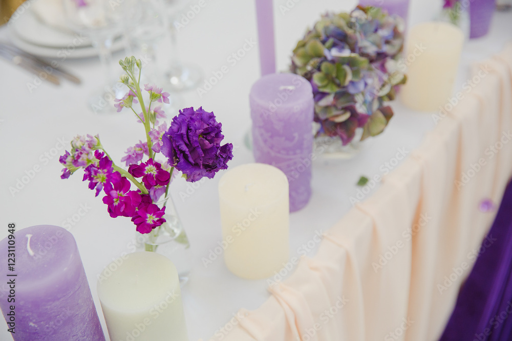 Tender violet spring flowers stand on a white table behind the c Tender violet spring flowers stand on a white table behind the c