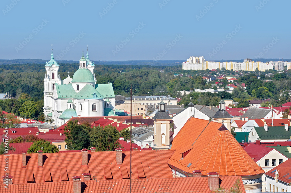Panoramic view of Grodno, Belarus. The historic city center with red tile roofs and the old Catholic church in the Baroque style during the day.