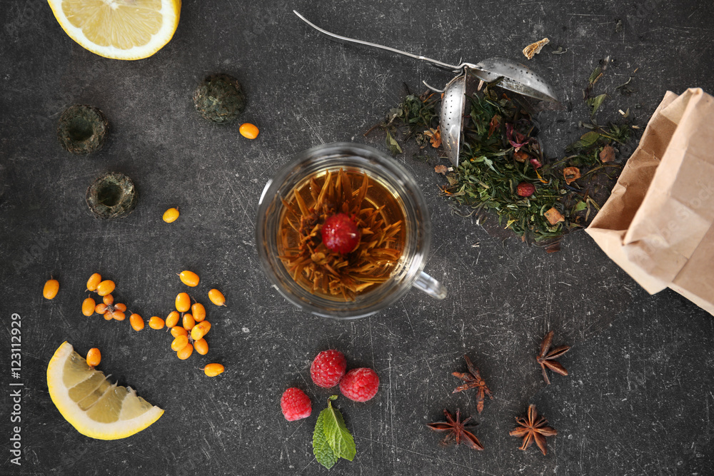 Fresh tasty tea ingredients and berries on grey background