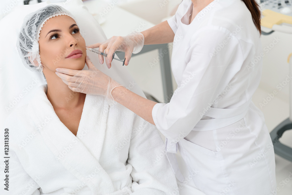 Experienced surgeon giving cosmetic injection Experienced surgeon giving cosmetic injection