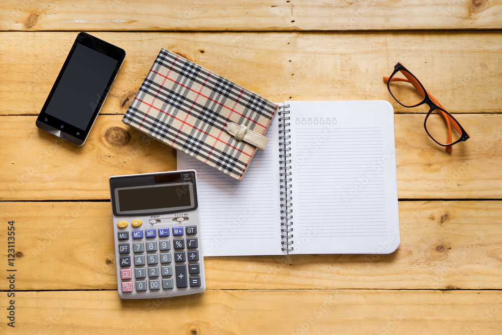 Papernote with mobile, eyeglasses and calculator on the wood tab Papernote with mobile, eyeglasses and calculator on the wood tab