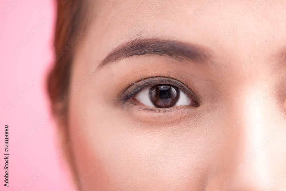 Beautiful asian woman eye with long eyelashes isolated on pink b Beautiful asian woman eye with long eyelashes isolated on pink b