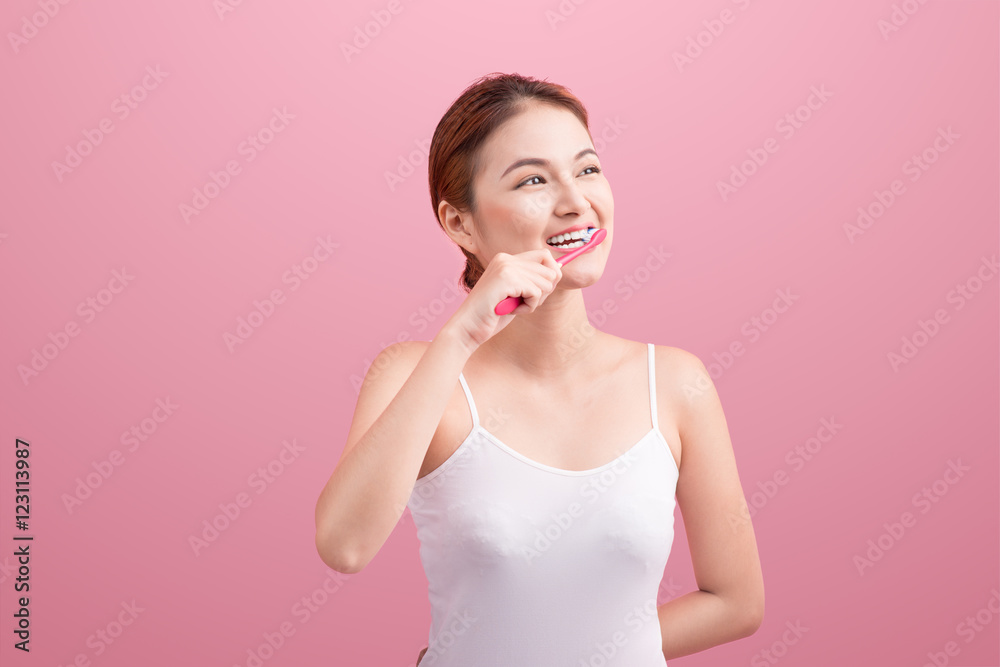 Smiling young woman with healthy teeth holding a tooth brush ove Smiling young woman with healthy teeth holding a tooth brush ove