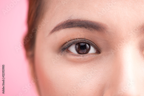 Fototapeta Naklejka Na Ścianę i Meble -  Beautiful asian woman eye with long eyelashes isolated on pink b