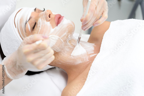 Professional beautician treating female skin by foam