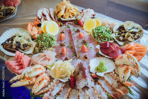 Tasty salted sea products lie together with souces on a serving photo