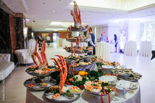 A look from behind on the rich buffet with sea products standing