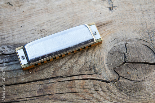 Blues harmonica music instrument on a old wood background