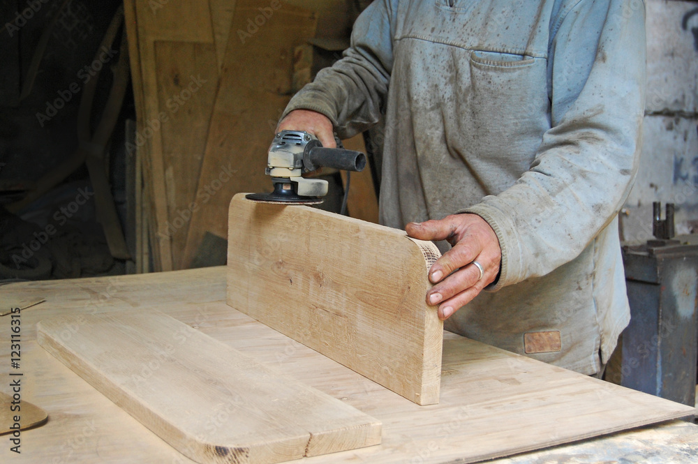 Carpenter polishing a wooden surface, hand and electrical polisher, sanding a plate, polishing wood
