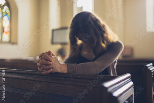 Foto Young woman praying in church