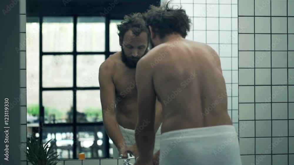Sleepy, young man in towel washing his face in bathroom
Sleepy, young man in towel washing his face in bathroom