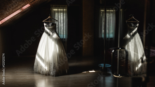 Wedding dress hanging on a hanger in the dark