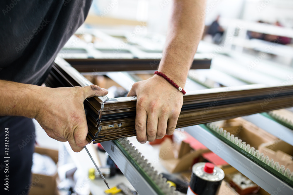 Manual worker assembling PVC doors and windows. Manufacturing jobs