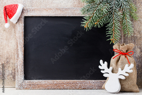 Christmas chalkboard and decoration over wooden background.