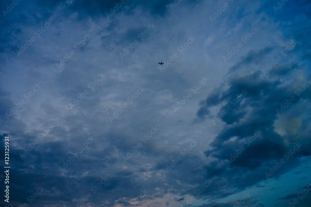 Obraz premium Flugzeug im dramatischen, wolkenverhangenen Abendhimmel