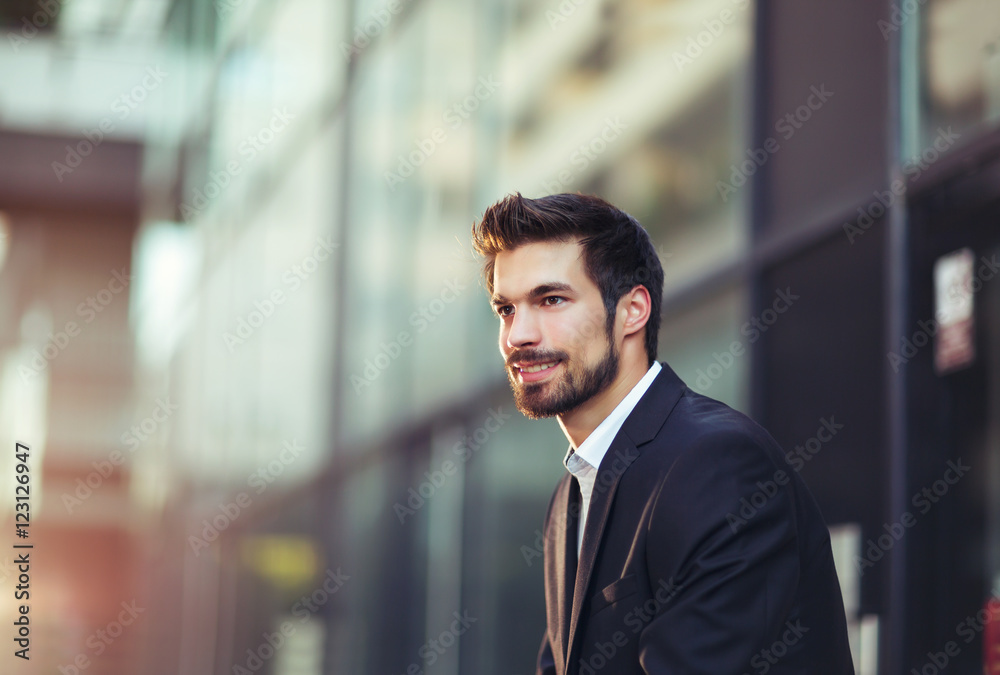 Portrait of a young happy businessman outside the office building Portrait of a young happy businessman outside the office building