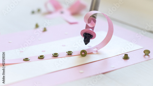 tool to insert eyelets and pink ribbon