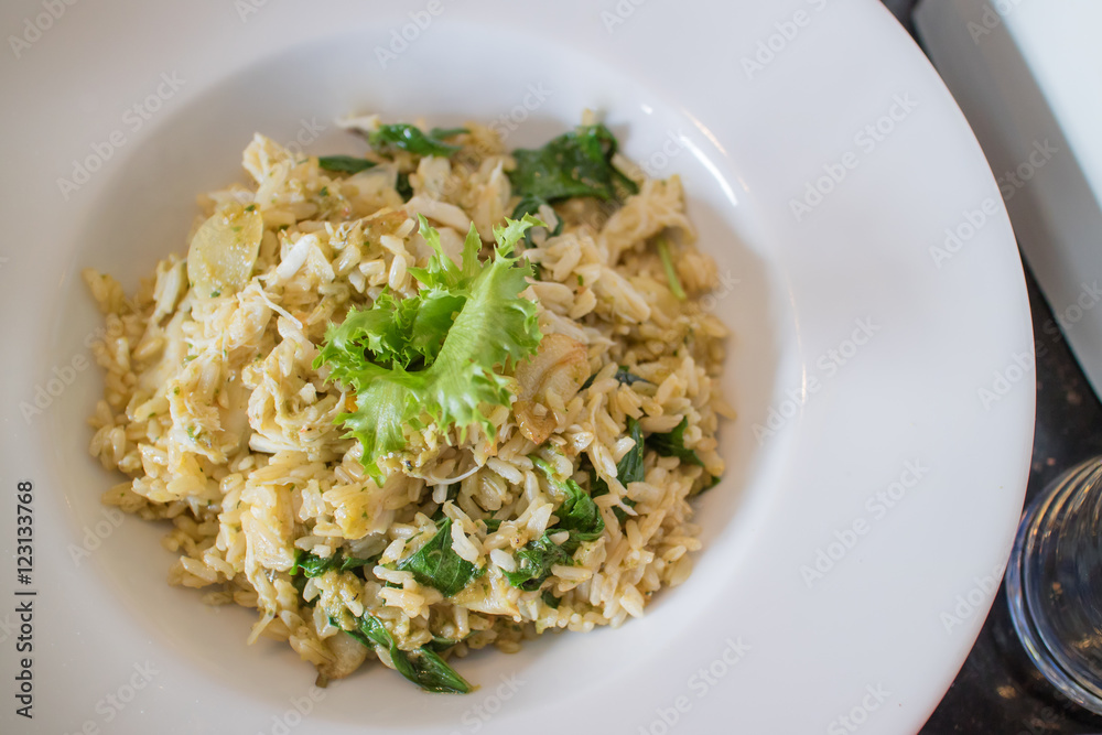 Risotto with crab meat and herbs in white plate