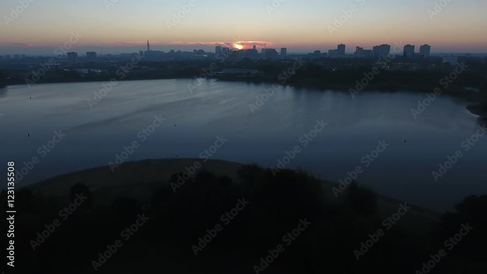 Aerial view flying towards Edgbaston reservoir at sunrise, Birmingham city centre in the distance. Aerial view flying towards Edgbaston reservoir at sunrise, Birmingham city centre in the distance.